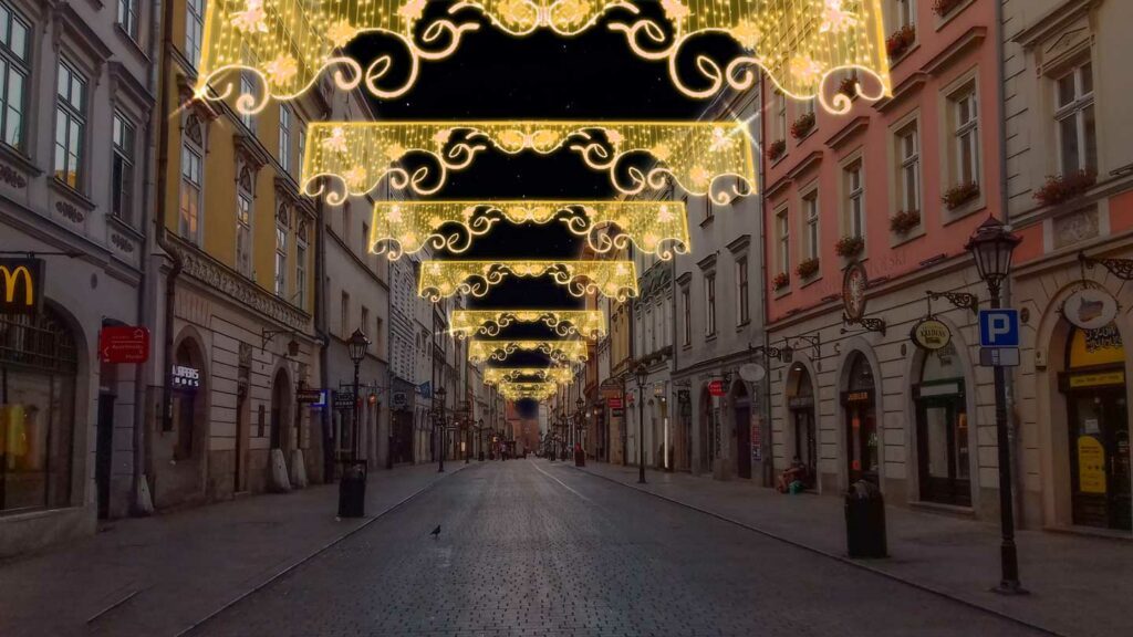 Allestimento natalizio di una via con soggetti luminosi a forma di motivi arabeschi colore bianco caldo